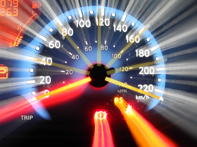 A zoom-exposure of a car's tachometer showing rapid acceleration from 0 to top-end speed (over 220 km/hr).