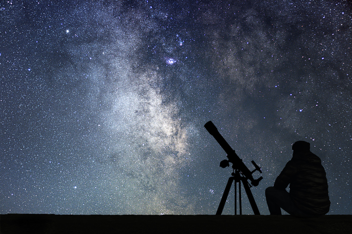 Man with astronomy  telescope looking at the stars. Man telescope and starry sky. Night sky. Milky way galaxy.