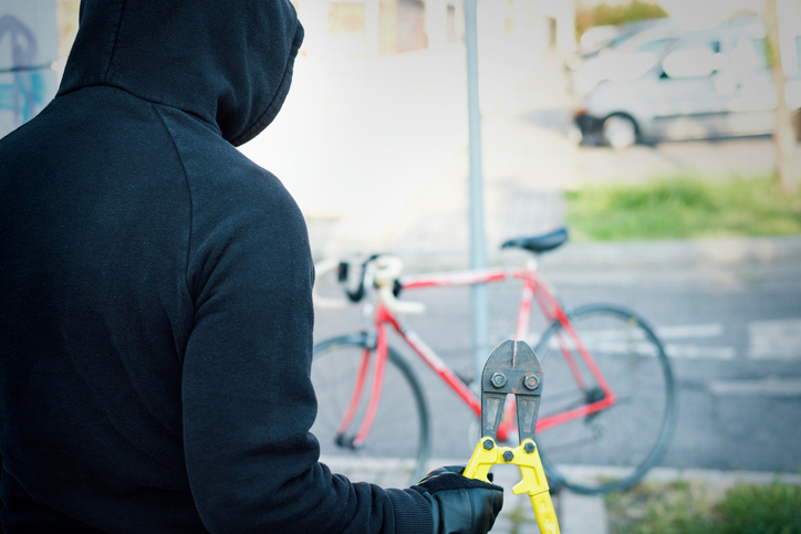 Thief stealing a parked bike in the city street